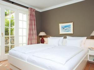 a large white bed in a bedroom with a window at Prahl-Hues-1 in Kampen