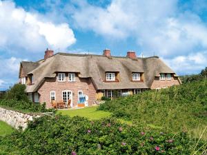 a large house with a thatched roof on a hill at Prahl-Hues-1 in Kampen