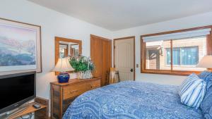 a bedroom with a bed and a flat screen tv at Ghostriders 5 by AvantStay 2 Bedroom Condo Near Main Street Hiking Skiing STR permit 3571 in Telluride