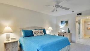 Un dormitorio con una cama azul con dos mesitas de noche. en Atlantic Paradise by AvantStay Great Location w Balcony Outdoor Dining Shared Pool Hot Tub, en Key West 22 fotos más
