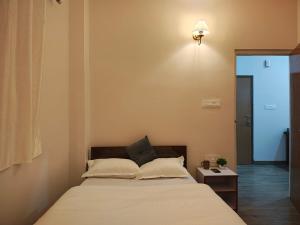 a bedroom with a bed and a table with a lamp at The Namchi Perch in Namchi