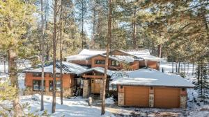 una baita di tronchi nel bosco con la neve sopra. di Base Camp by AvantStay Magical Cabin w Sauna Hot Tub Close to Snow Golf a Sunriver