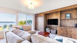 a living room with a large couch and a tv at Saratoga by the Sea by AvantStay Panoramic View Near Langley in Langley