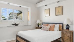 Un dormitorio blanco con una cama y una ventana. en Canalfront Charmer by AvantStay Waterfront w Shared Dock Hot Tub, en Newport Beach