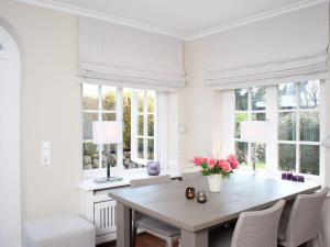 a dining room with a table and chairs and windows at Vis-a-Vis in Kampen +3 photos