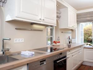 a kitchen with white cabinets and a sink at Vis-a-Vis in Kampen