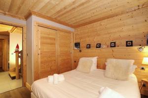 a bedroom with a bed in a wooden room at Charming village chalet in Saint-Bon-Tarentaise