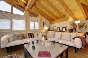 a living room with white couches and a table at Charming village chalet in Saint-Bon-Tarentaise