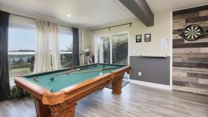 a pool table in a living room with a large window at Fairway Harbor View by AvantStay Outdoor Oasis in Freeland