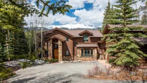 Una casa de troncos con una montaña cubierta de nieve en Zendo by AvantStay Serene Mountain Abode w Hot Tub Views, en Breckenridge