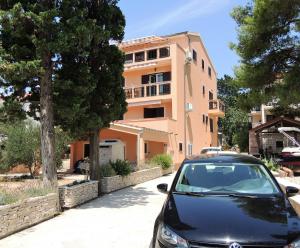 un coche negro estacionado frente a un edificio en Apartments Denona, en Novalja