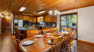 a kitchen and dining room with a wooden table and chairs at Whiskey Springs by AvantStay Classic Cabin Near Tahoe Donner Ski Area in Truckee