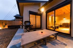 a house with a wooden table on a patio at mg-mgream- in Shima