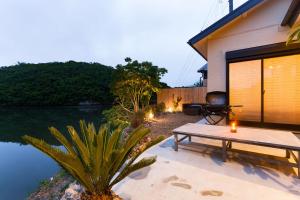 a patio with a table and a grill next to a lake at mg-mgream- in Shima