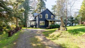 a blue house in the middle of a field at Westside Waterfront View Home - AvantStay Hot tub in Greenbank
