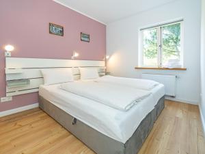 a large bed in a bedroom with pink walls at Haus-Fahnert-2 in Kampen