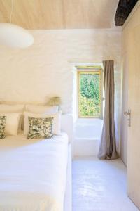 a bedroom with two beds and a window at Historic Chestnut Kiln With Pool In The Cévennes in Les Plantiers