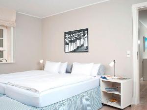 una camera da letto con un grande letto bianco e un tavolo di Haus-zum-Leuchtturm a Kampen
