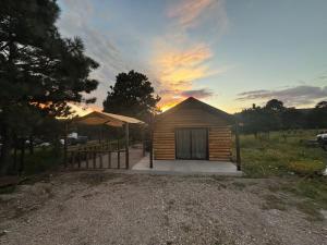 a small wooden cabin with a sunset in the background at Cabañas La Esperanza in Creel