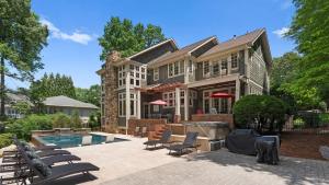 a house with a swimming pool in front of it at Boathouse Cove by AvantStay Pool Swim Dock Hot Tub in Lake Norman of Catawba