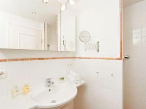 a white bathroom with a sink and a mirror at Kampen-Kliff-3 in Kampen