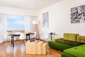 a living room with a green couch and a table at Fiesta Inn Queretaro Centro Sur in Querétaro