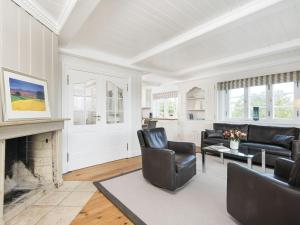 a living room with black chairs and a fireplace at Wattenhof-1 in Kampen