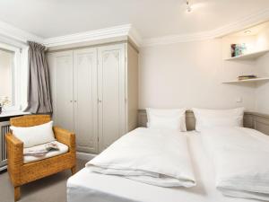 a bedroom with two beds and a chair at Wattenhof-1 in Kampen