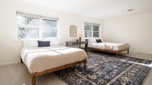 a bedroom with two beds and a rug at Clementine By AvantStay Bright Modern Retreat w Pool Pool Table Large Patio in Santa Rosa