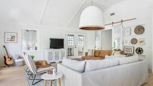 a living room with a couch and a table at Cast Away by AvantStay Stunning Modern Home Near Beach w Two Kitchens in Isle of Palms