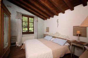 a bedroom with a bed and a desk and a window at Premignaga Natural Home in Gardone Riviera