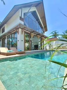 eine Villa mit Swimmingpool und ein Haus in der Unterkunft Luxury 3 bedroom villa Kupu Kupu in Nusa Lembongan