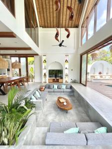 ein offenes Wohnzimmer mit einem Sofa und einem Tisch in der Unterkunft Luxury 3 bedroom villa Kupu Kupu in Nusa Lembongan + 25 Fotos