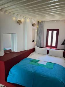 Un dormitorio con una cama grande con una manta azul. en Rooftop House in the heart of the Médina, en Tánger