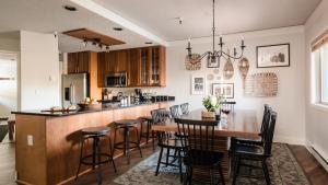 cocina con barra con sillas y mesa en Rocker by AvantStay Gorgeous Ski-In Ski-Out Cabin in Heart of Breck, en Breckenridge