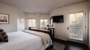 Un dormitorio con una cama y un televisor de pantalla plana. en Rocker by AvantStay Gorgeous Ski-In Ski-Out Cabin in Heart of Breck, en Breckenridge