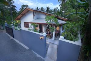 a house with a blue door and a fence at Onadi House in Galle