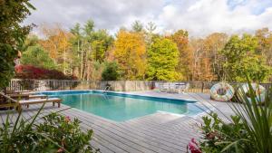 a backyard pool with a wooden deck and a swimming pool at Cortland by AvantStay Charming Heritage Estate w Private Lake Pool in Saugerties