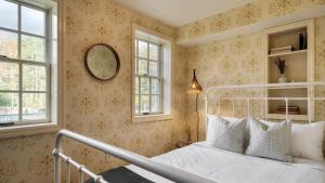 a bedroom with a white bed and two windows at Cortland by AvantStay Charming Heritage Estate w Private Lake Pool in Saugerties +21 photos