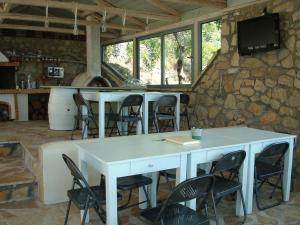 a white table and chairs in a room with a stone wall at Merlot Village Rental Properties in Kariá