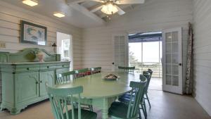 une salle à manger avec une table et des chaises vertes dans l'établissement 1111 Middle Street by AvantStay Charming Historic Cottage Featured in Dear John Movie Beach Access, à Sullivans Island