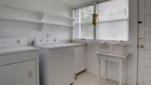 una cucina bianca con lavandino e lavastoviglie di 1111 Middle Street by AvantStay Charming Historic Cottage Featured in Dear John Movie Beach Access a Sullivan's Island Altre 40 foto
