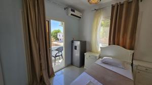 a bedroom with a bed and a window with a balcony at Manzzel Dahab Hostel in Dahab