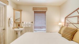 a white bedroom with a large bed and a sink at Double Diamond 23 by AvantStay Close to Town The Slopes in Telluride