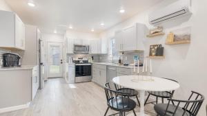 una cucina con mobili bianchi, tavolo e sedie di Bear’s Place by AvantStay Cozy Mountain Cabin in Brevard Firepit a Brevard