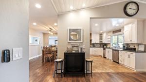 a kitchen and dining room with a clock on the wall at Breathtaking Meadows by AvantStay Temecula Group Retreat Pool Pickleball Firepit Hot Tub in Temecula