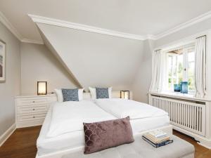 a white bedroom with a white bed and a window at Hansenhoog-4 in Kampen