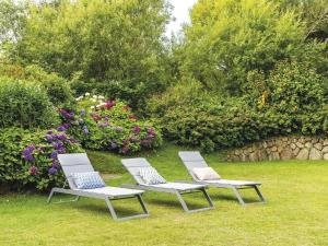 two white chairs sitting in a yard with flowers at Hansenhoog-4 in Kampen +6 photos