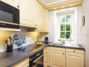 a kitchen with white cabinets and a sink and a window at Hansenhoog-3 in Kampen +4 photos