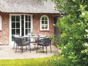 a patio with a table and chairs in front of a brick house at Hansenhoog-3 in Kampen